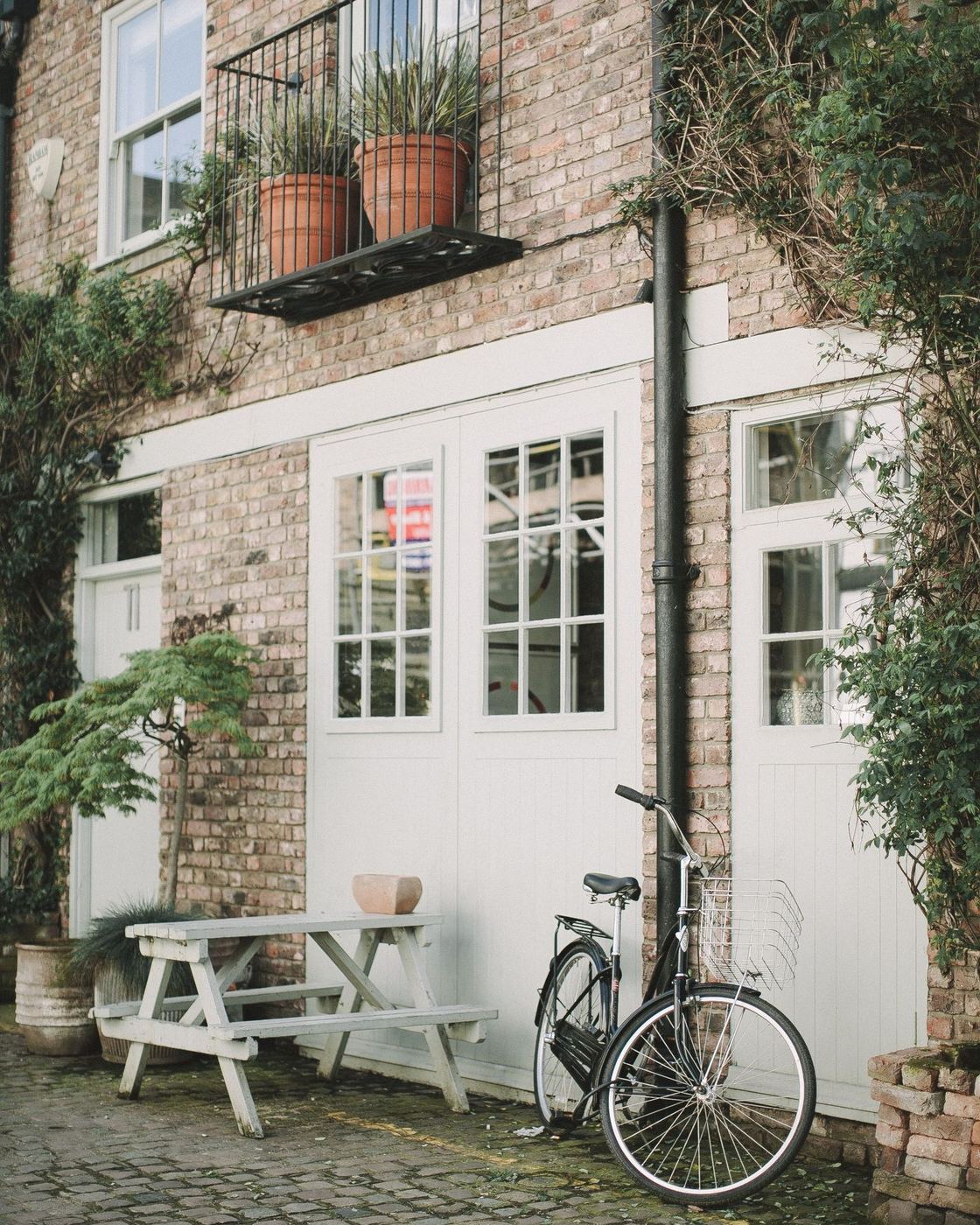 A brick home with white-painted doors and sash windows on a cobbled lane — the kind of property we work on around Sevenoaks