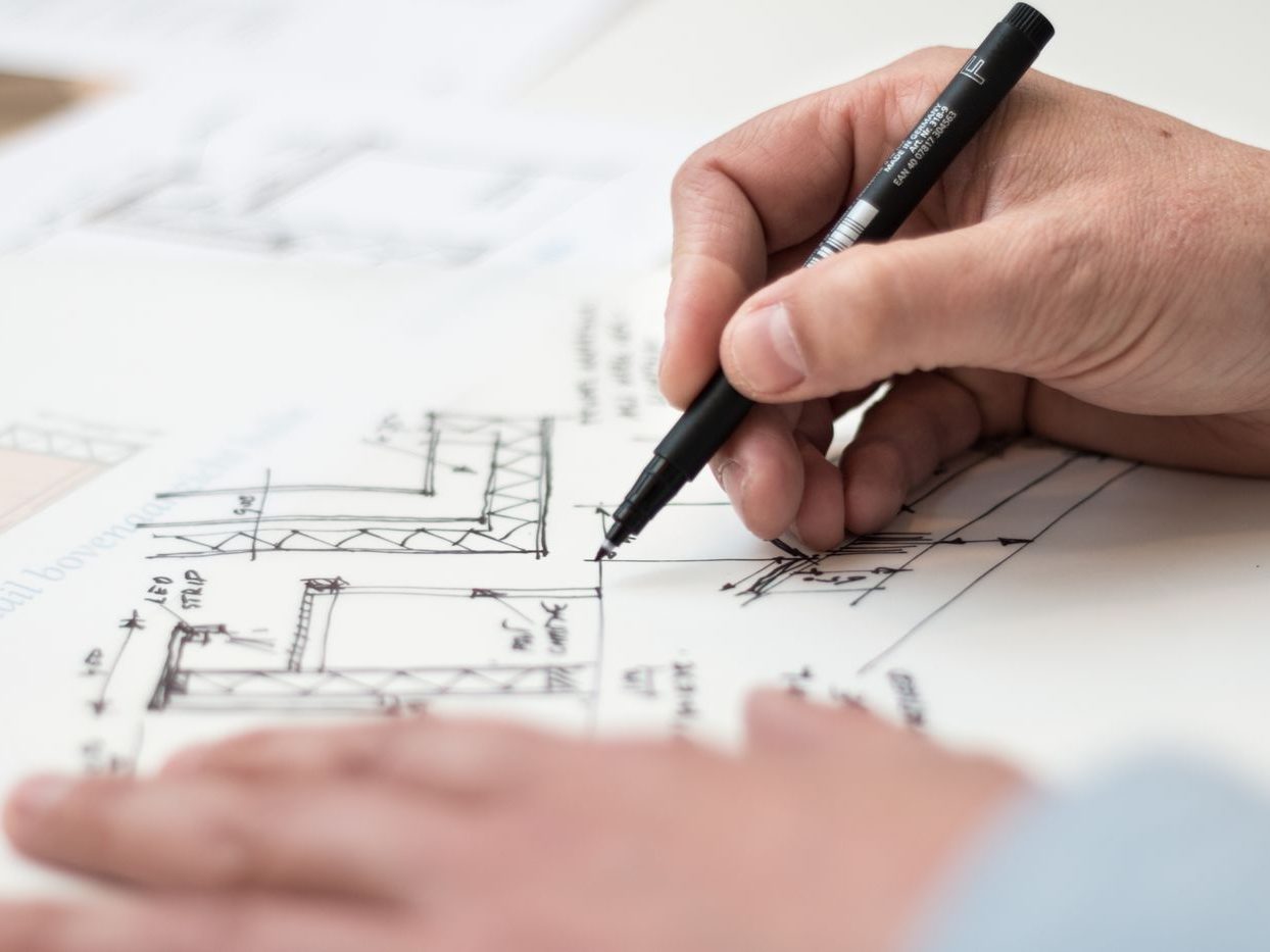 A hand marking up a set of construction drawings
